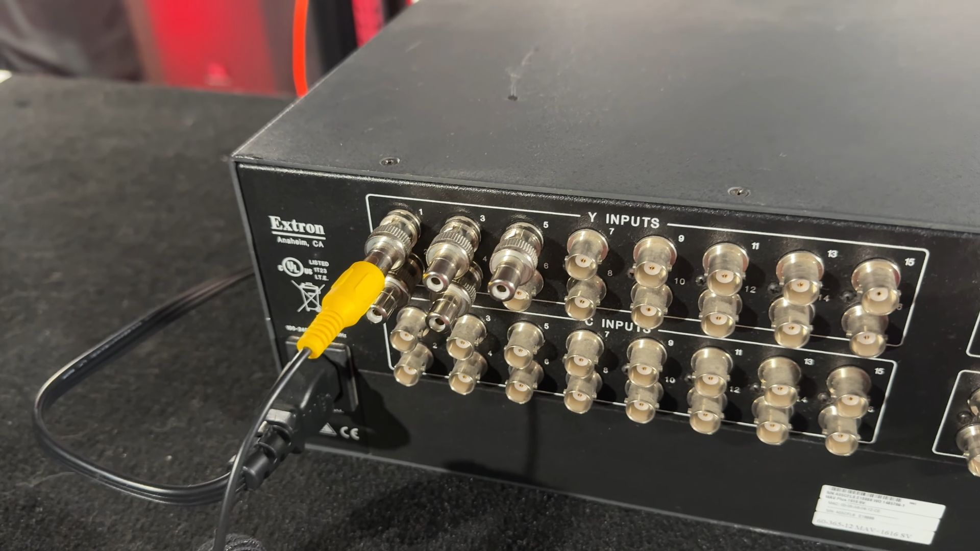 The rear of the Extron matrix switcher shows multiple BNC connectors for Y and C inputs, with one BNC connector adapted to RCA.