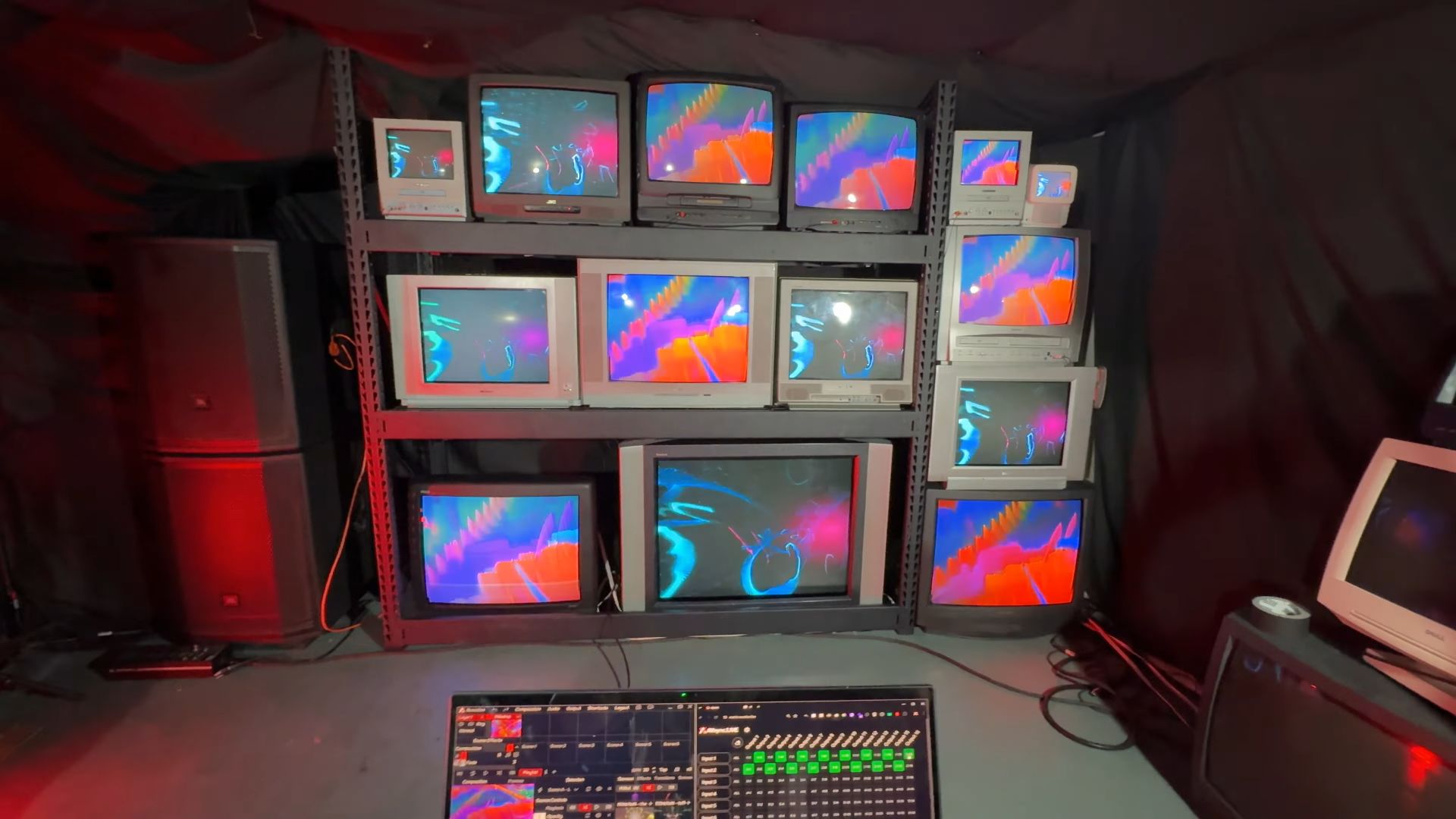 Two different video signals are routed to various CRT TVs on a shelving unit, controlled by matrix software on a laptop in the foreground.