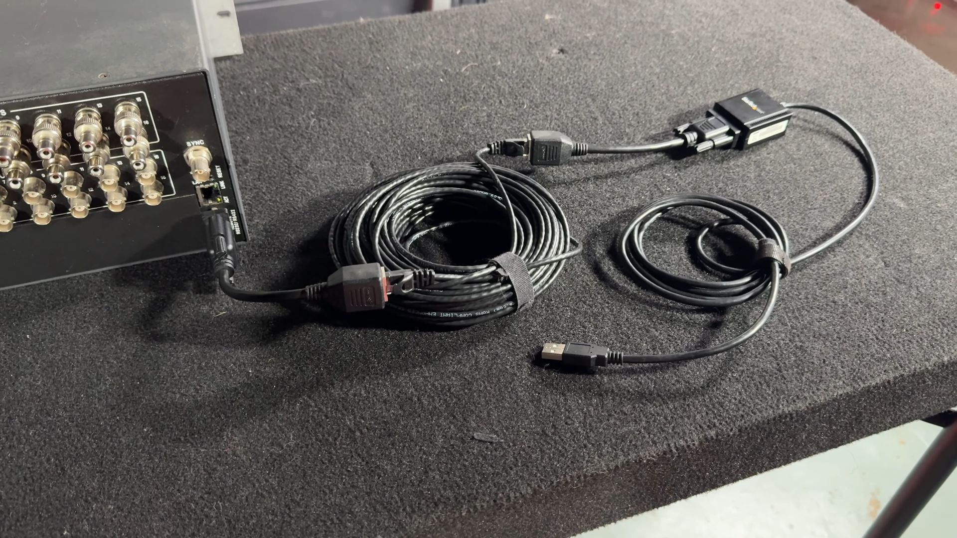 A Cat5 adapter is connected to the Extron matrix switcher, extending the range of the serial control connection for remote operation.