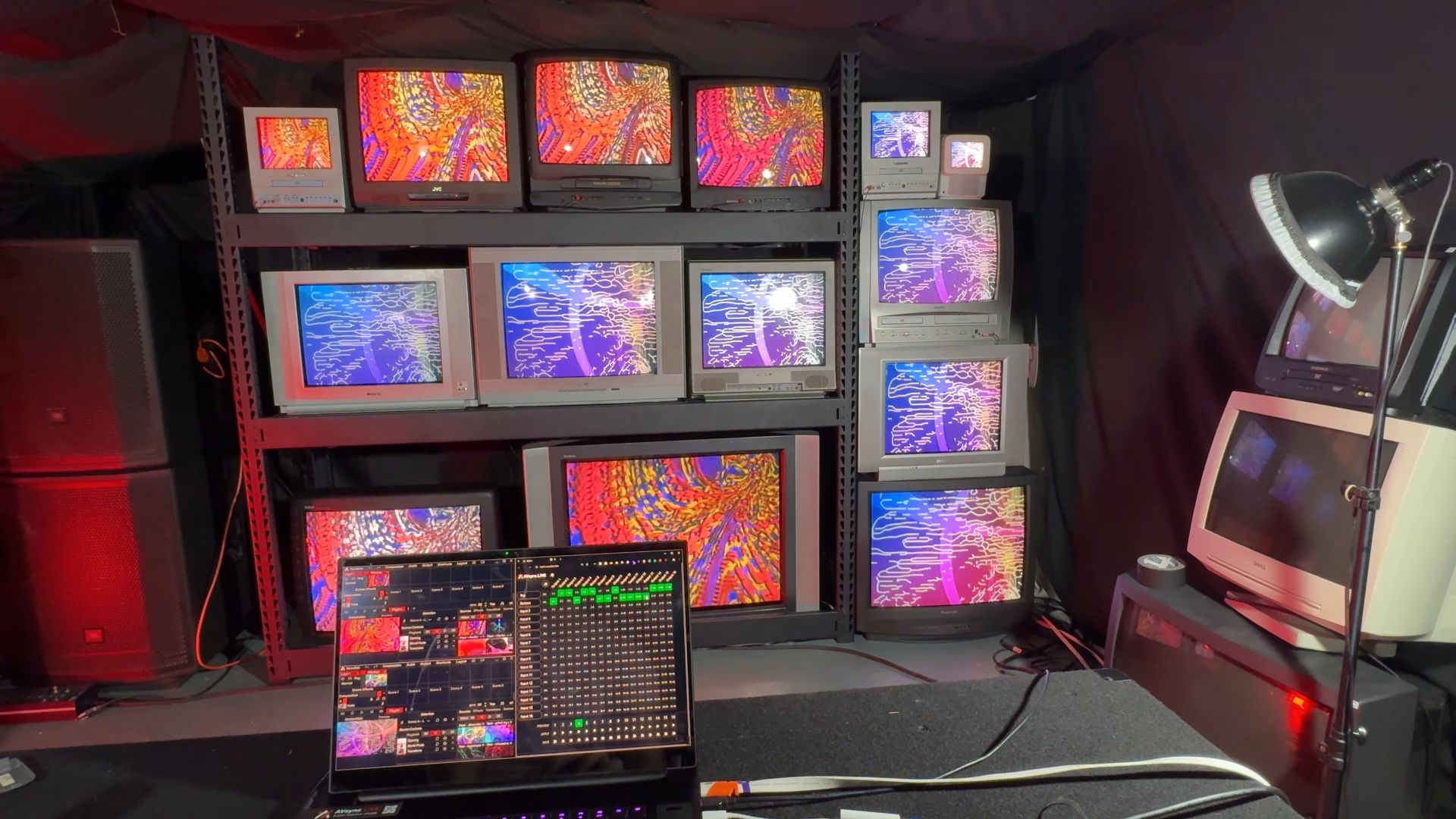 The image shows a matrix of CRT TVs displaying two distinct video signals, managed via the matrix control software visible on the laptop in the foreground.